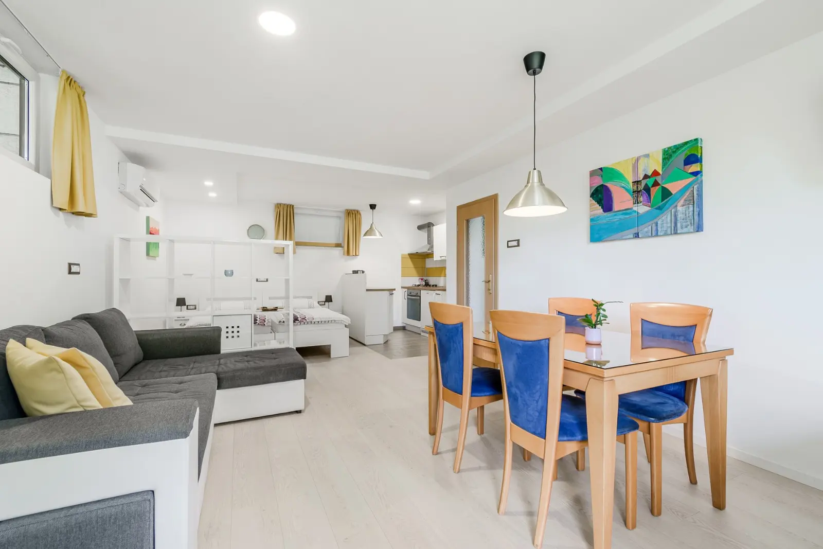Dnevni prostor apartmaja Arena z jedilno mizo, kavčem in kuhinjo v ozadju
